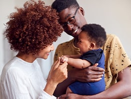 Smiling mom and dad holding baby
