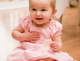 Smiling baby girl touching her chest