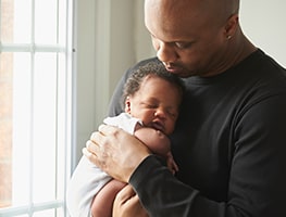 Dad holding a sleeping baby