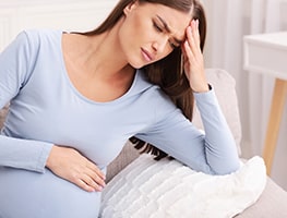 Pregnant woman holding her belly in discomfort